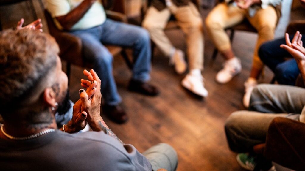 Men applauding in group therapy at mental health center